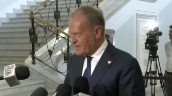 Tusk ze spuszczoną głową wychodzi od Hołowni